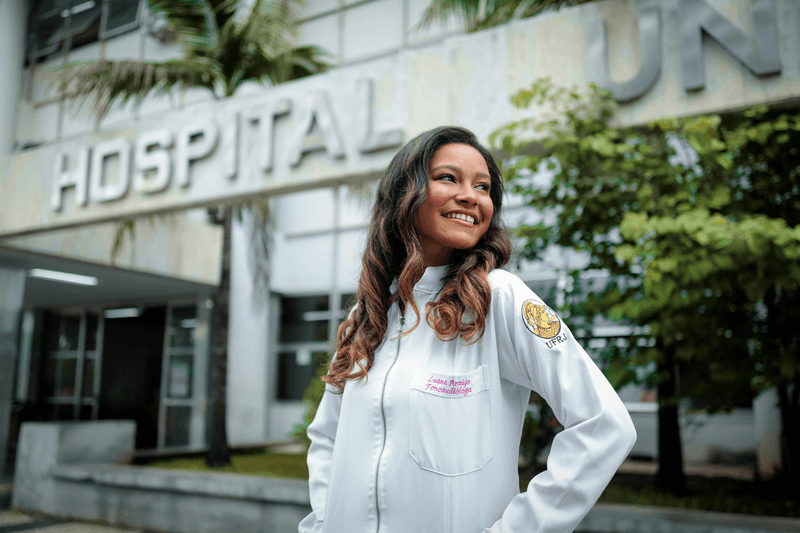 woman in a lab coat standing in front of a hostpital